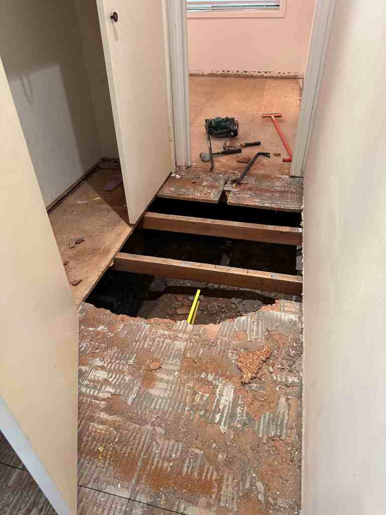 Floorplan Studio hallway with exposed floor joists and construction tools.